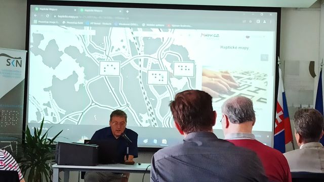 Prednášajúci Petr Červenka počas konferencie, v pozadí reliéfna mapa Levoče